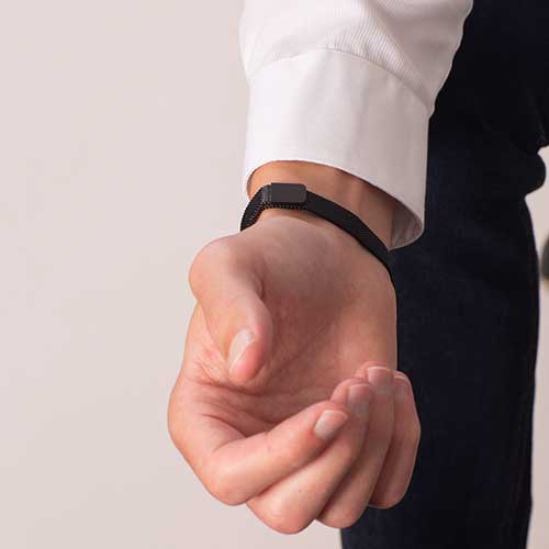 Man showing adjustable, magnetic clasp on black stainless steel mesh band.