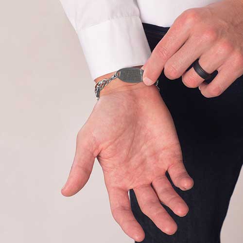 Man showing custom engraved medical ID tag with premium laser engraving
