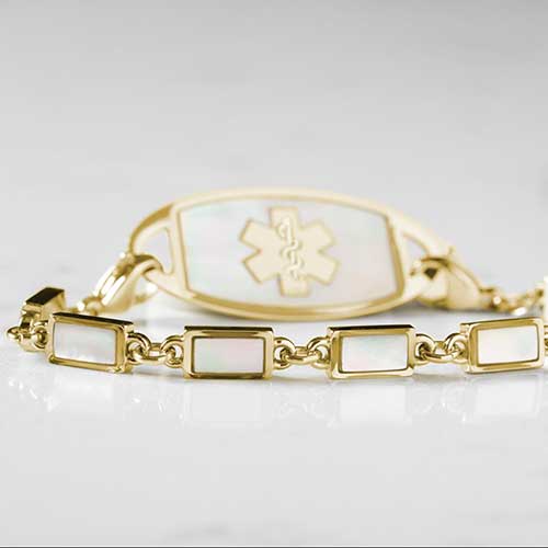 Single strand medical alert bracelet with yellow gold links and mother of pearl inlay and mother of pearl medical ID tag