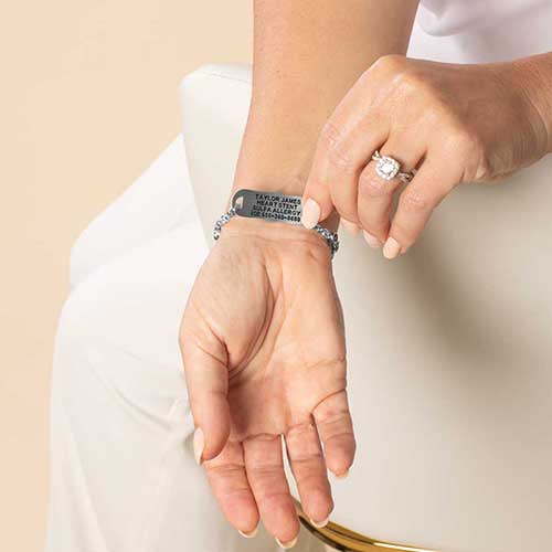 Woman wearing stainless steel medical id tag with premium laser engraving.