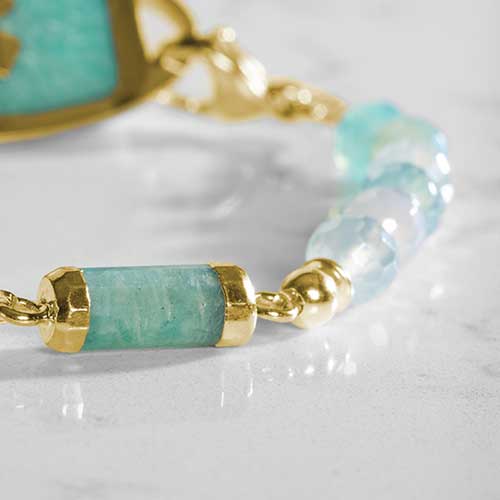 Close up of green beads and barrel centerpiece on gold toned medical ID bracelet