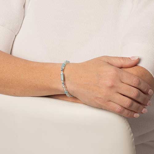 Woman showing her green beaded medical ID bracelet.