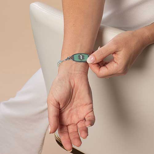 Woman showing her silver and Amazonite medical ID tag