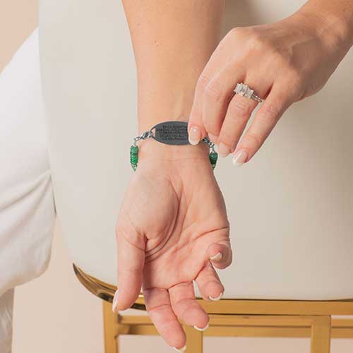 Woman displaying custom laser engraved text on the back of her medical ID