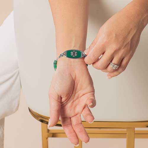 Woman displaying decorative medical ID with Green watercolor inlay