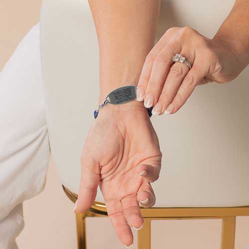 Woman showing her custom laser engraved details on the back of her medical ID