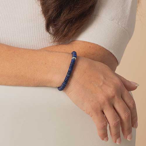 Woman wearing blue lapis and silver beaded bracelet