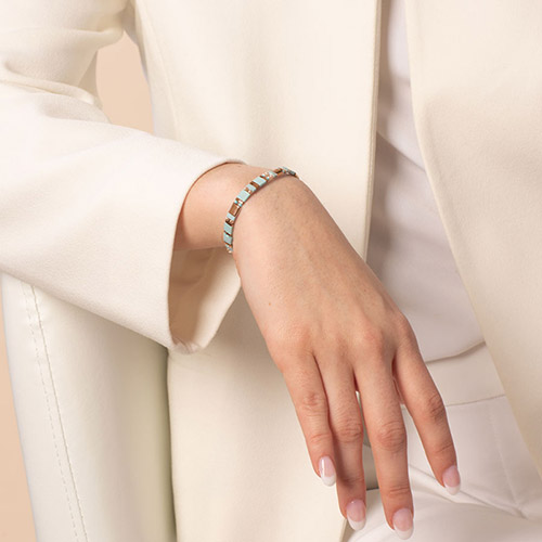 Elegant rose mother-of-pearl medical ID bracelet worn on wrist, featuring an engraved medical alert emblem on a stylish metal plate.
