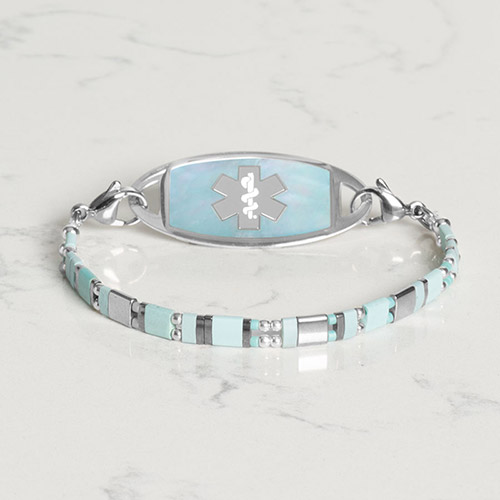 Flat lay of a silver medical ID bracelet featuring a polished metal plate and elegant mother-of-pearl inlay.