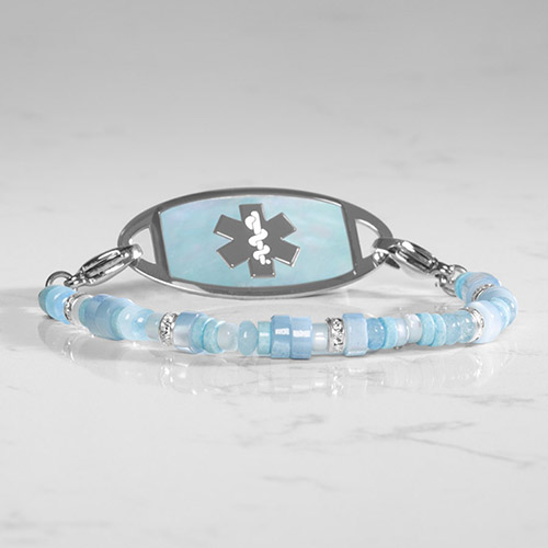 Flat lay of a silver medical ID bracelet with a mother-of-pearl inlay, highlighting its elegant design and safety features.