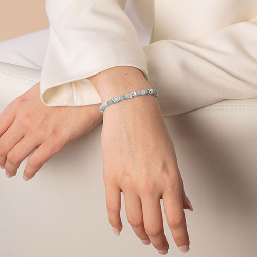 Elegant silver medical ID bracelet worn on wrist, showcasing a sleek metal plate with an engraved medical alert emblem.