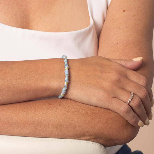 Gold medical ID bracelet worn on wrist, showcasing a sleek metal plate with an engraved medical alert emblem for stylish safety.