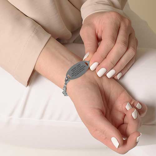 Woman wearing stainless steel medical ID tag with premium laser engraving.