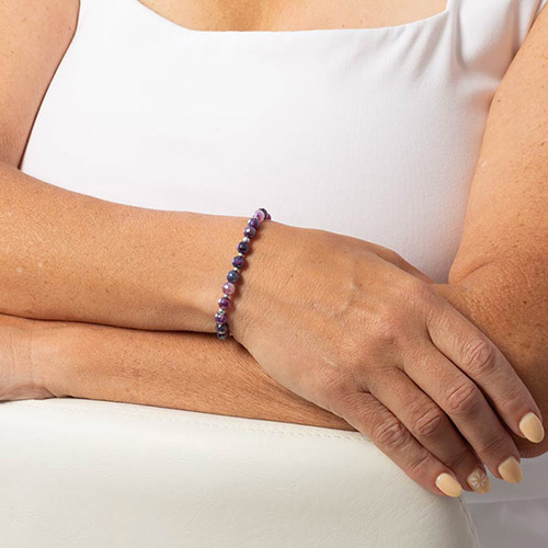 Woman wearing beaded bracelet featuring purple agate beads and silver filled beads.