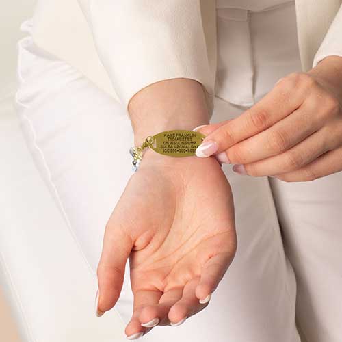 Personalized medical ID bracelet with a blue mother-of-pearl inlay, featuring custom engraving for essential medical information.