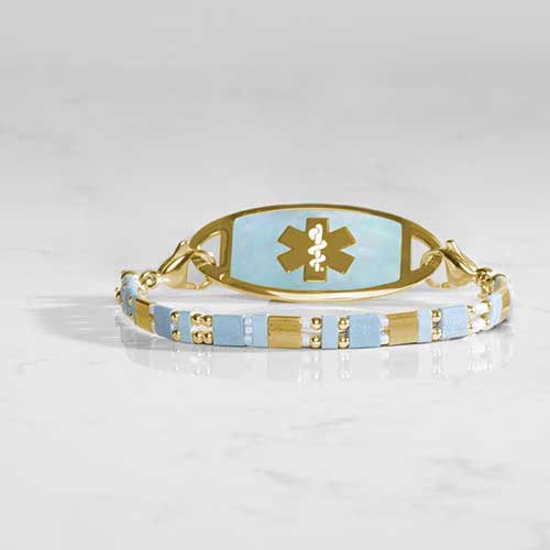 Stylish medical ID bracelet with an aqua and gold mother-of-pearl inlay, featuring an engraved medical alert emblem on a durable metal plate. Elegant and functional design for everyday wear.