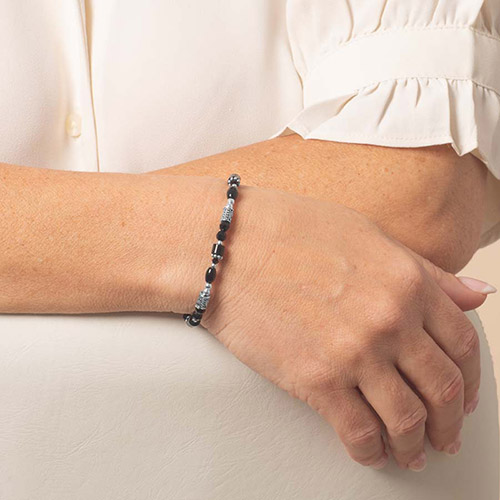 Close-up of black and silver beaded medical ID bracelet on woman's wrist, showcasing Lauren’s Hope Livi style in silver finish.