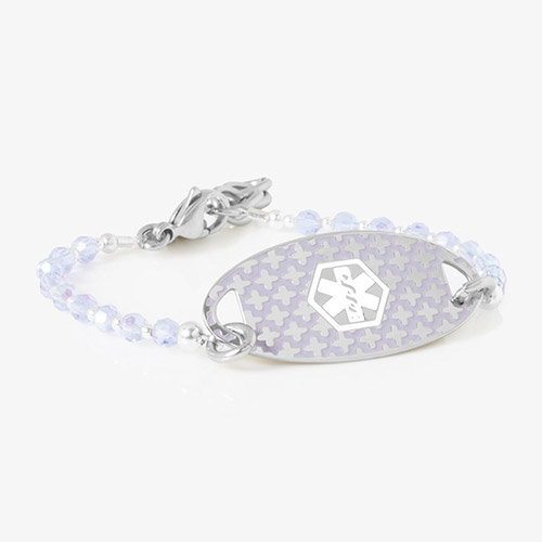 Delicate medical ID bracelet with lavender iridescent beads and a silver oval tag featuring a subtle medical symbol with a cross pattern.