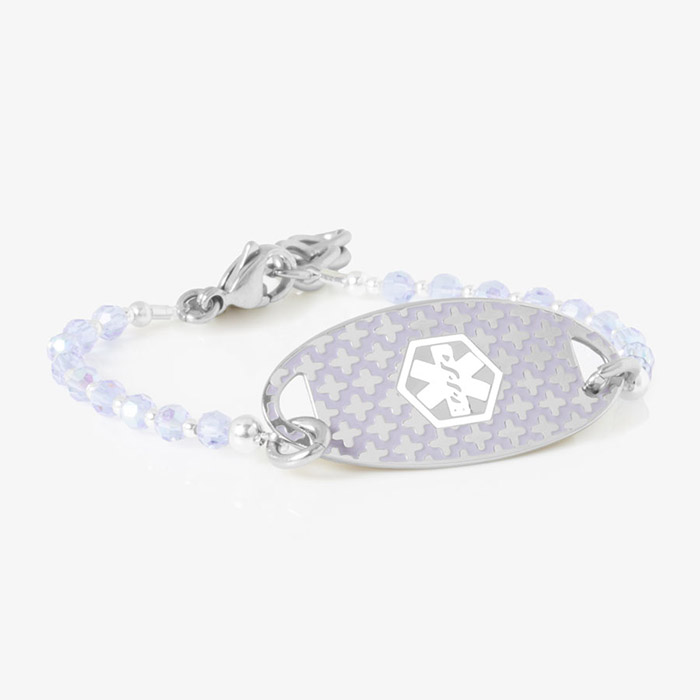 Delicate medical ID bracelet with lavender iridescent beads and a silver oval tag featuring a subtle medical symbol with a cross pattern.