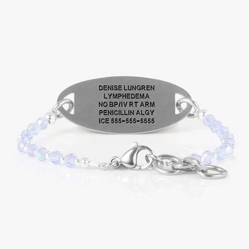 The same bracelet flipped to display custom-engraved medical information on the brushed silver ID tag.