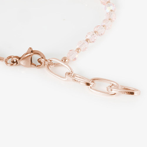 Close-up of rose gold lobster clasp and chain extender on pink SmartStretch beaded bracelet.