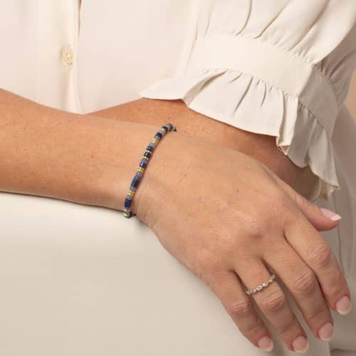 Woman with displaying blue and Gold beaded stretch medical ID bracelet.