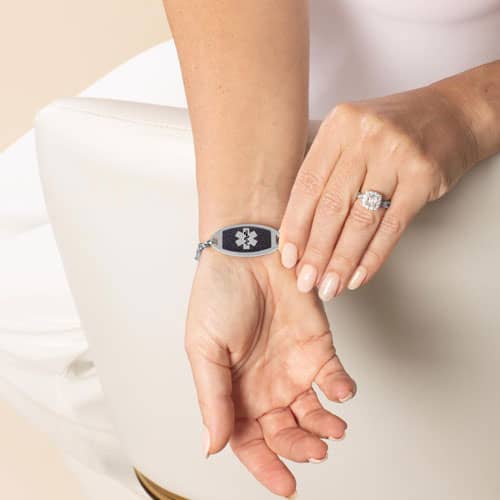 Model displaying the front of a medical ID bracelet featuring a midnight blue inlay and medical alert symbol paired with the Bree bracelet.