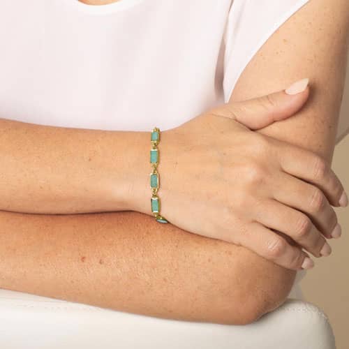 Woman wearing Gold tone linked medical ID bracelet featuring Amazonite stone inlays, attached to a gold tone medical ID tag with inlaid Amazonite and gold medical ID symbol.