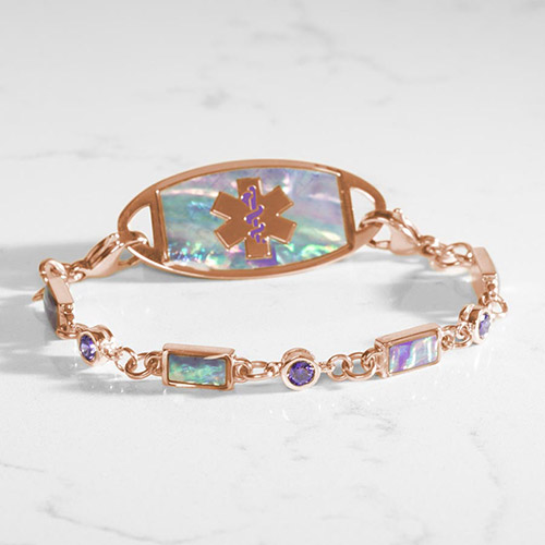 Stylish rose gold medical alert bracelet with lilac abalone inlay and violet accents, displayed on a marble surface.