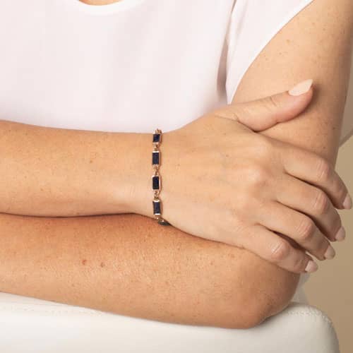 Woman wearing the rose gold-tone bracelet with midnight-blue glitter inlay links on her wrist.