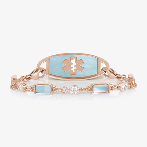 Rose gold medical ID bracelet with pale blue mother-of-pearl inlay and clear crystal accents, paired with rose gold ID tag.