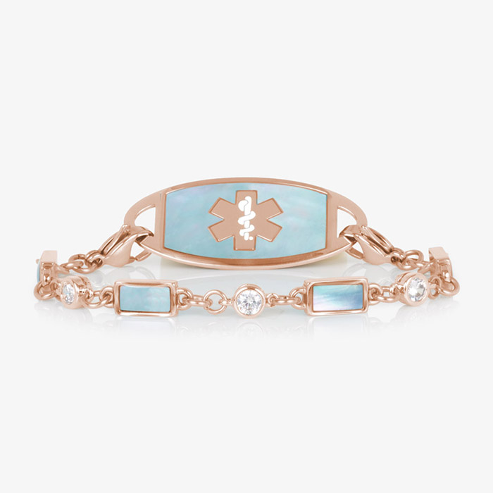 Rose gold medical ID bracelet with pale blue mother-of-pearl inlay and clear crystal accents, paired with rose gold ID tag.