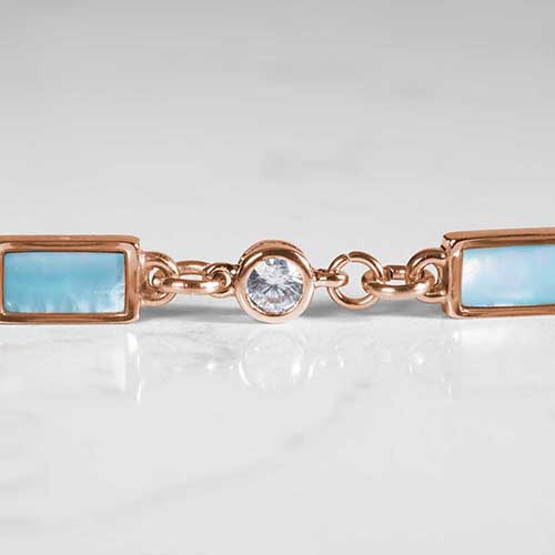 Detail of round, clear, crystal, and rectangular blue mother of pearl inlays on marble.