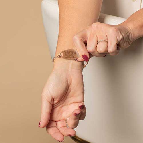 Woman displaying the custom, laser engraved, medical details on her ID.