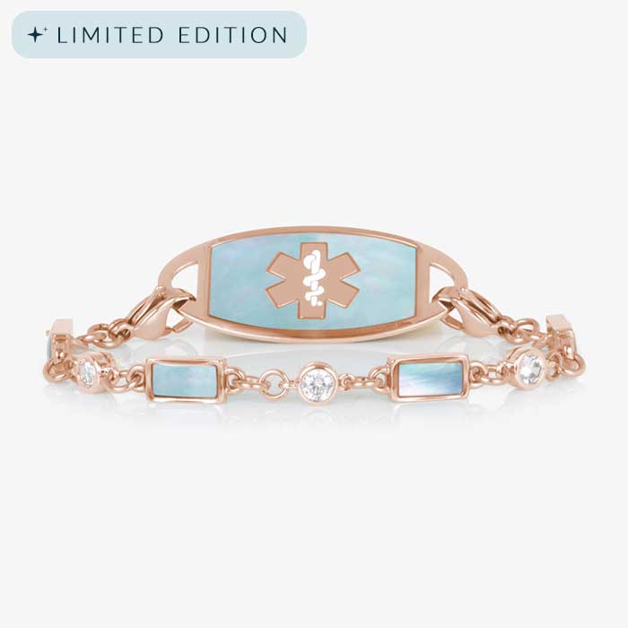 Rose gold medical ID bracelet with pale blue mother-of-pearl inlay and clear crystal accents, paired with rose gold ID tag.