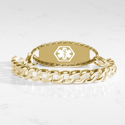 Men's gold medical ID bracelet with a chunky curb chain and white medical emblem on a matching gold ID tag, styled on a light marble surface.