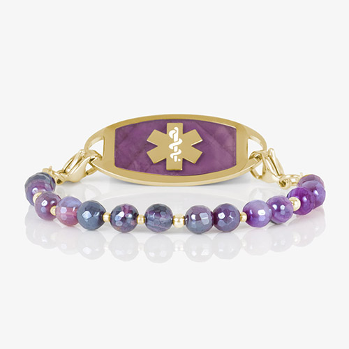 Studio image of a purple and gold medical ID bracelet featuring faceted ombré agate beads and a gold tag with purple inlay and a gold medical alert symbol.