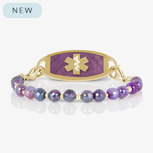 Studio image of a purple and gold medical ID bracelet featuring faceted ombré agate beads and a gold tag with purple inlay and a gold medical alert symbol.
