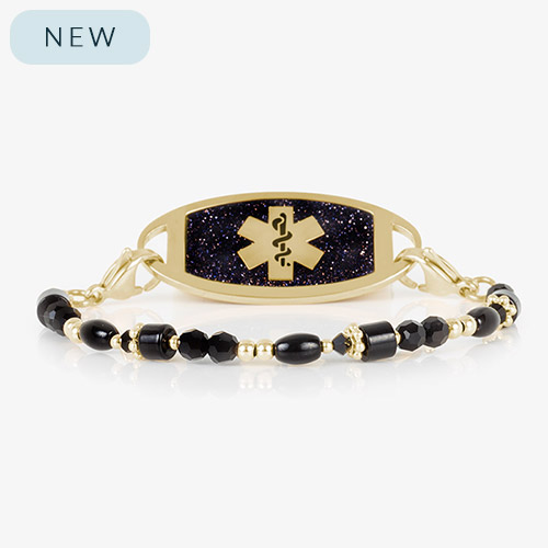 Gold and black medical ID bracelet featuring a navy blue glitter tag with a gold medical caduceus symbol, displayed on a white background.