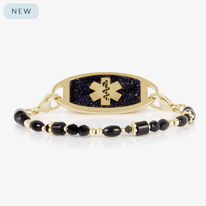 Gold and black medical ID bracelet featuring a navy blue glitter tag with a gold medical caduceus symbol, displayed on a white background.