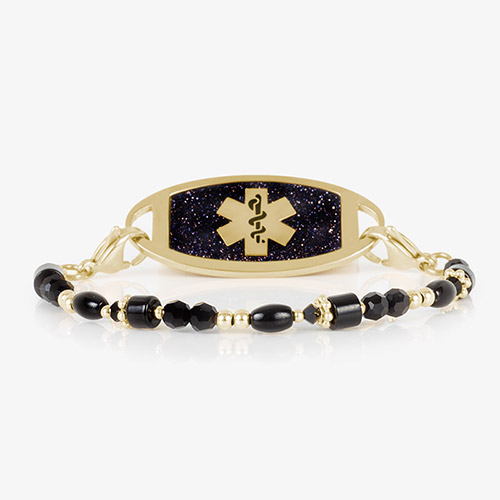 Gold and black medical ID bracelet featuring a navy blue glitter tag with a gold medical caduceus symbol, displayed on a white background.