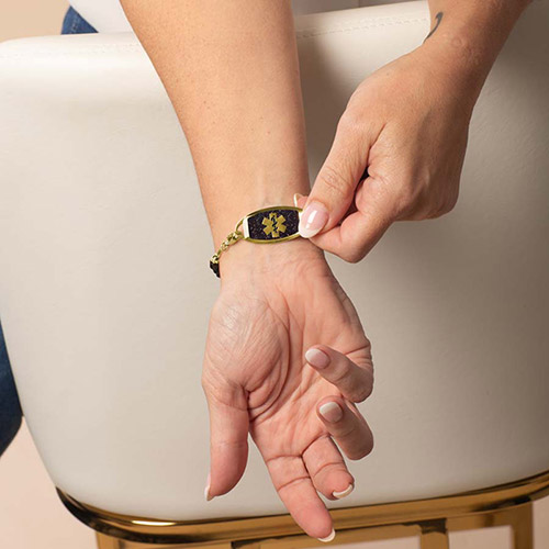 Lauren’s Hope gold medical ID tag with black enamel medical symbol, worn with Livi style black and gold beaded bracelet.