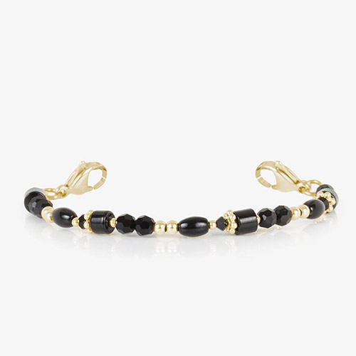Close-up of the Livi strand in black and gold tones, showcasing a mix of black beads, faceted crystals, and gold accent spacers with lobster clasps at both ends.