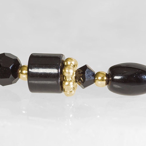 Beaded medical bracelet with glossy black, faceted, and gold accent beads, shown on a white background.
