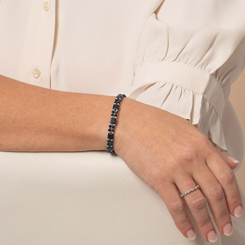 Close-up of a woman’s wrist wearing the Jett medical ID bracelet, showcasing the glittery blue medical tag with silver medical alert symbol.