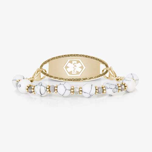 White marbled beads paired with gold tone beads, stretch medical ID bracelet paired with a gold tone medical ID tag featuring a white caduceus symbol.