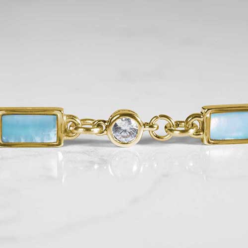 Detail of round, clear, crystal, and rectangular blue mother of pearl inlays on marble.