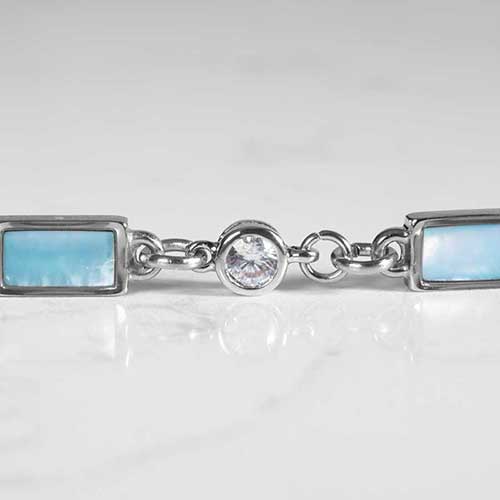 Detail of round, clear, crystal, and rectangular blue mother of pearl inlays on marble.