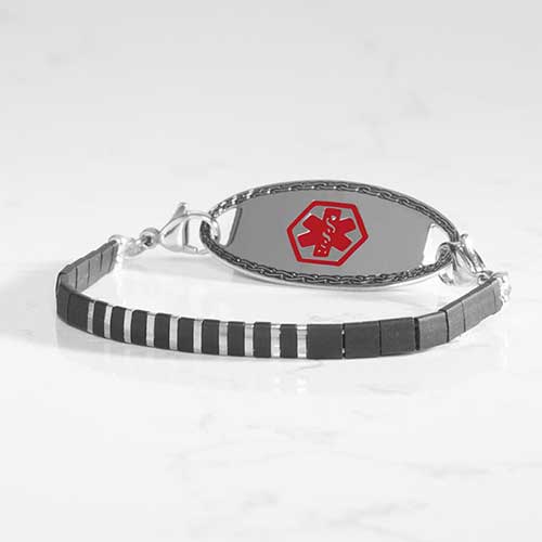 Silver-tone medical ID braceletfeaturing silver and black tila beads and a polished silver tone medical ID tag with red cadu.