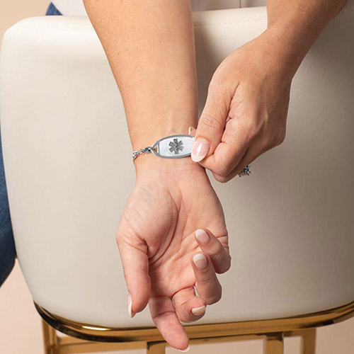 Nova 1 interchangeable medical ID bracelet in silver and multitone tile design shown on wrist, featuring a silver tag with the medical symbol clearly displayed for fast emergency identification.